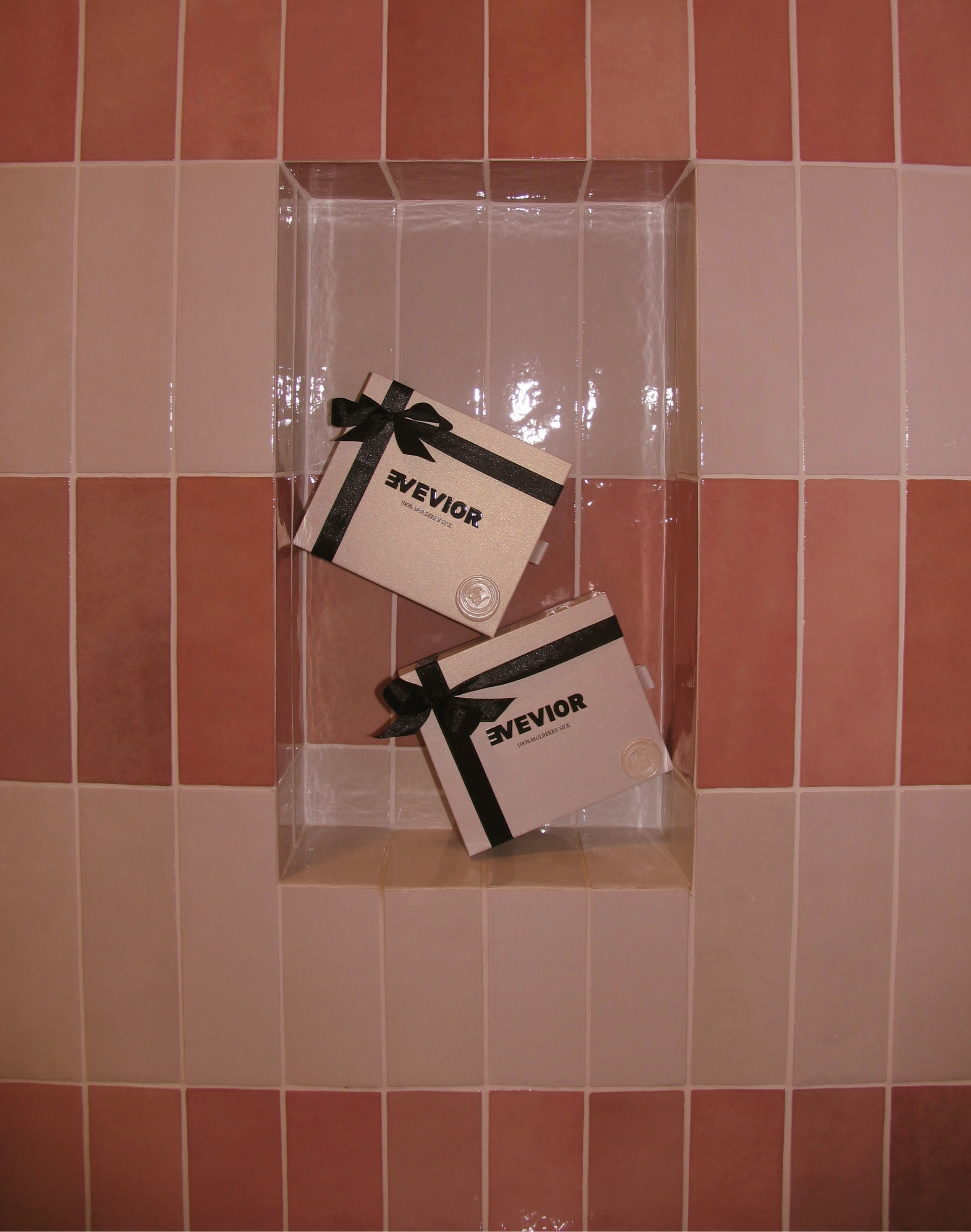 Two Evevior packaging boxes displayed in a tiled wall niche.
