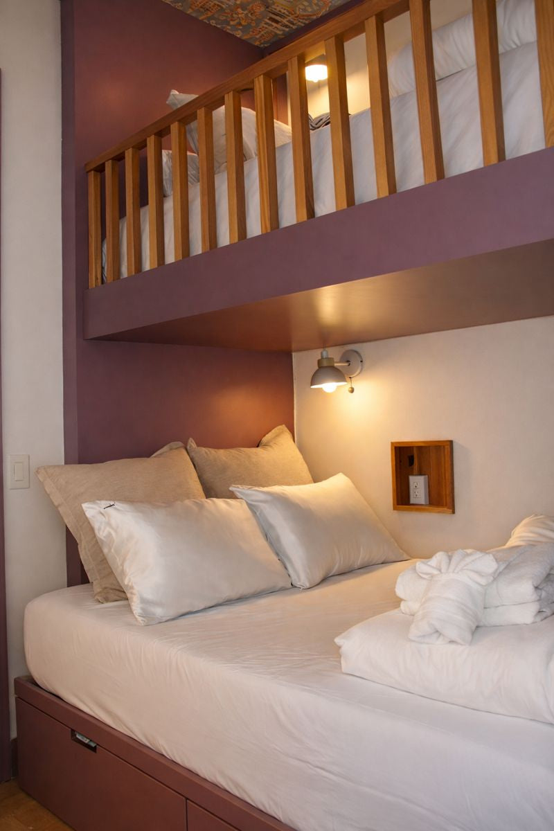 Neatly made bed with white and two white silk pillows in a cozy room.
