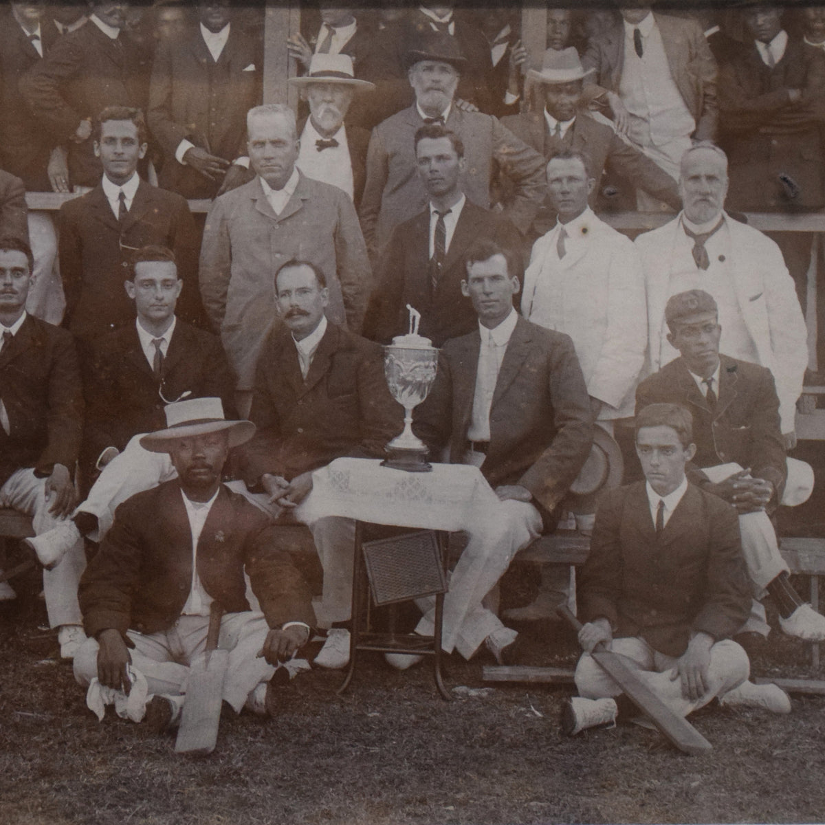 Vintage black and white photograph of a group of men in formal attire with a trophy.