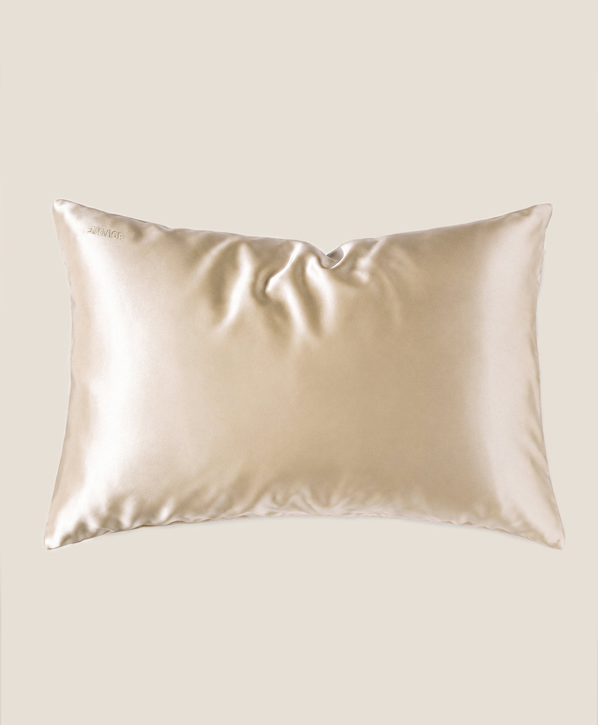 A pillow covered in a beige silk pillowcase with a subtle sheen, shown against a solid beige background